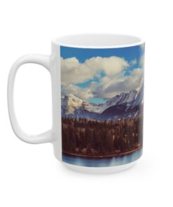 The scenic mountain landscape with snow-capped peaks, evergreen trees, and a cloudy blue sky.