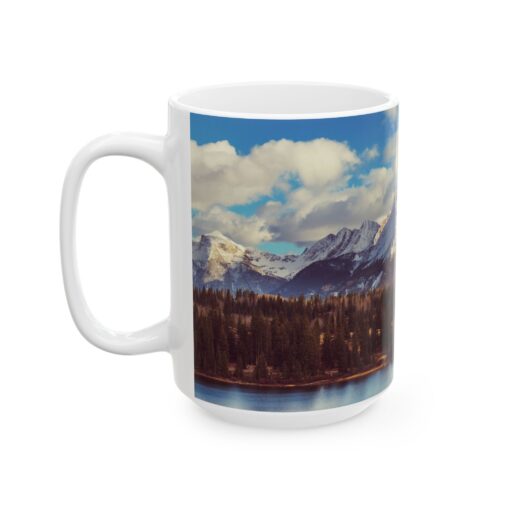 The scenic mountain landscape with snow-capped peaks, evergreen trees, and a cloudy blue sky.