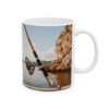 a mug with a fishing pole and a rock in the background