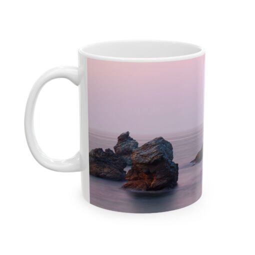 Coffee mug with rocks on the beach on it