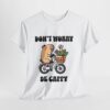 a white t-shirt with a cartoon character riding a bicycle