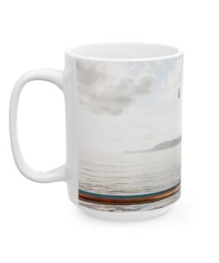 a white coffee mug with a picture of a boat on the water