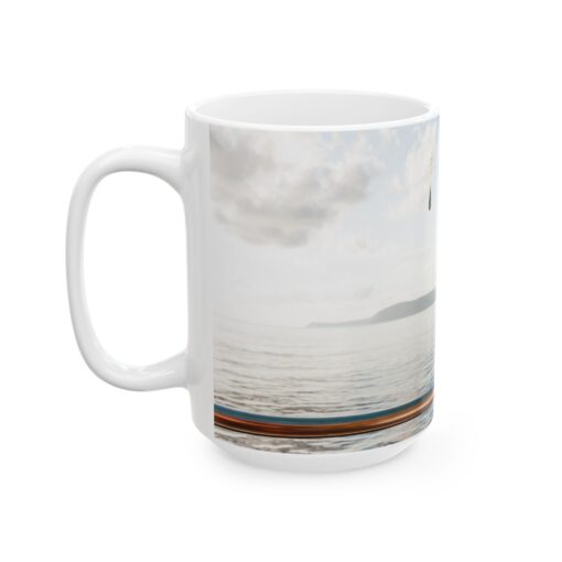 a white coffee mug with a picture of a boat on the water