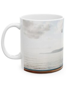 a white coffee mug with a picture of a body of water