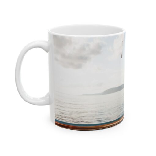 a white coffee mug with a picture of a body of water